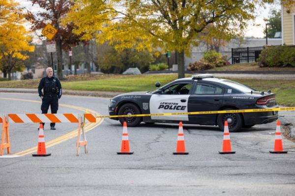 A police officer blocks access to a road leading to a bowling alley where seven people were fatally shot on Wednesday night.