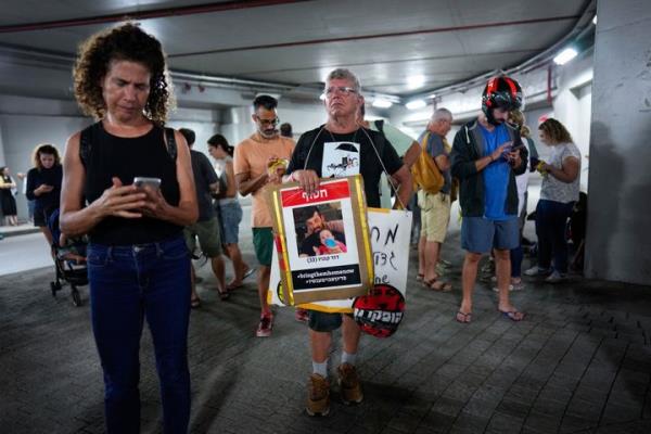 Israelis take cover in an underground car tunnel as a siren warns of incoming rockets fired from the Gaza Strip, during a protest calling for the return of more than 220 people captured by Hamas militants, in Tel Aviv, Israel, Saturday, Oct. 28, 2023. (AP Photo/Bernat Armangue)